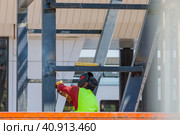 A man-welder fastens iron girders with a welding machine. Construction of the station. Стоковое фото, фотограф Юрий Поздников / Фотобанк Лори