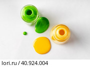 Bright colored nail polish bottles with drippings on white background. Стоковое фото, фотограф Сергей Толмачёв / Фотобанк Лори