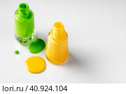 Bright colored nail polish bottles with drippings on white background. Стоковое фото, фотограф Сергей Толмачёв / Фотобанк Лори