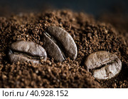 Три кофейных зернышка лежат на молотом кофе, крупный план. Стоковое фото, фотограф E. O. / Фотобанк Лори