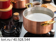 Copper pot with boiling water on a gas stove. Стоковое фото, фотограф Сергей Толмачёв / Фотобанк Лори