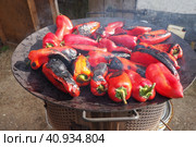 Roasting red peppers for a smoky flavor and quick peeling. Thermal processing of the pepper crop on a metal circle. Brazier container used to burn charcoal fuel for cooking, heating or cultural ritual. Стоковое фото, фотограф Юлия Петровская / Фотобанк Лори