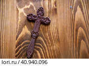 Православный крест лежит на деревянном столе в церкви (2023 год). Редакционное фото, фотограф Николай Винокуров / Фотобанк Лори