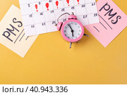 Календарь месячных, будильник на желтом фоне. Приход менструального цикла, ПМС, критические дни. Место для текста. Стоковое фото, фотограф Айгуль Миннибаева / Фотобанк Лори