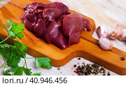 Raw rabbit liver on wooden table. Стоковое фото, фотограф Яков Филимонов / Фотобанк Лори