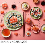 Smooth laying out of various sushi rolls on plates with chopsticks on the table. Created by AI. Стоковое AI-изображение, AI-художник Ярославский Максим / Фотобанк Лори