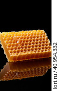 Golden wax honeycombs with honey lie on a shiny black background. Created by AI. Стоковое AI-изображение, AI-художник Ярославский Максим / Фотобанк Лори