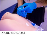 Девушка учится делать укол в попу на манекене (2023 год). Редакционное фото, фотограф Николай Винокуров / Фотобанк Лори