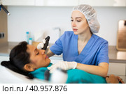 Beautician doing needle-free mesotherapy for hispanic woman. Стоковое фото, фотограф Яков Филимонов / Фотобанк Лори