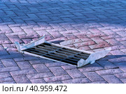 Iron gratings for storm sewers, lined with paving slabs. The hole is closed with a plastic bag in autumn to prevent clogging of underground utilities. The concept of urban critical infrastructure. Стоковое фото, фотограф Алексей Игнатов / Фотобанк Лори