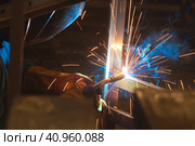 Welder welds metal parts, lots of smoke and sparks, harmfulness, worker. Стоковое фото, фотограф Стас Пересыпкин / Фотобанк Лори