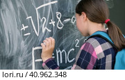 Sad pupil trying to solve an example. Schoolgirl stands with her forehead on the blackboard. Teenage girl solving advanced mathematical problems and banging his head on chalkboard. This is too hard. Стоковое видео, видеограф Марина Демидюк / Фотобанк Лори