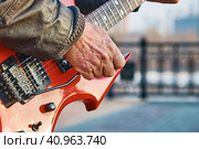 BLAGOVESHCHENSK, RUSSIA - MAY 01, 2022: Guitarist plays the electric guitar on the city embankment. Labor Day. Редакционное фото, фотограф Алексей Игнатов / Фотобанк Лори