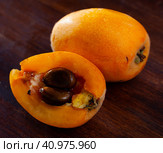 Whole and half fresh yellow loquat on wooden table. Стоковое фото, фотограф Яков Филимонов / Фотобанк Лори