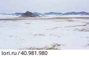 Горный Алтай зимой: одинокая гора в степи. Вид с воздуха. Altai mountains in winter: a lonely mountain among the steppe. Aerial view. Стоковое видео, видеограф Евгений Романов / Фотобанк Лори