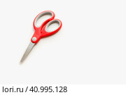 Канцелярские ножницы на белом фоне. Ножницы с красной ручкой. Stationery scissors on a white background. Scissors with a red handle. Стоковое фото, фотограф Ольга Митряева / Фотобанк Лори