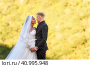 Портрет молодоженов крупным планом на фоне ярко освещенной листвы. Стоковое фото, фотограф Иванов Алексей / Фотобанк Лори