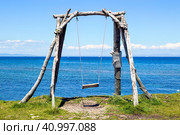 Wooden old swing without people on the background of the Japanese sea on a summer day. Стоковое фото, фотограф Татьяна Терехина / Фотобанк Лори