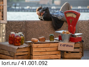 Продавец спит за прилавком на базаре.  Репетиция Алых парусов в Санкт-Петербурге, зона 90-х годов (2023 год). Стоковое фото, фотограф Литвяк Игорь / Фотобанк Лори