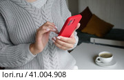 Female hand using cellphone. Close-up. Young woman holding smartphone in her hands and scrolling through the news feed. Person texting message, touching screen on smart phone. Shopping online. Стоковое видео, видеограф Марина Демидюк / Фотобанк Лори