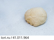 A piece of yeast dough is lying on the kitchen table waiting to be cooked. Кусок дрожжевого теста лежит на кухонном столе в ожидании приготовления. Стоковое фото, фотограф Дмитрий Березнев / Фотобанк Лори
