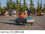 2022-08-12 Tatarstan, Verkhneuslonsky district, village. Savino. Resort town "Sviyazhsky hills". Kazan Festival of Historical Technologies. Children ride on children's retro cars. Редакционное фото, фотограф Алина Лебедь / Фотобанк Лори