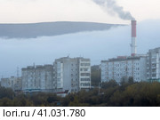 Вид на здания жилого квартала и дымящую трубу угольной ТЭЦ. Туманная погода. Экология в городах Сибири. Магадан, Магаданская область, Россия. Стоковое фото, фотограф Андрей Степанов / Фотобанк Лори