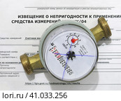 Поломка счетчика. Неисправный счетчик учета воды лежит на извещении о непригодности к применению (2023 год). Редакционное фото, фотограф Татьяна Т / Фотобанк Лори