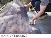 A close-up of the master's hands on the roof mounts flexible tiles. Стоковое фото, фотограф Кутина Татьяна / Фотобанк Лори