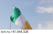 Big flag of Ireland fastened on stick against background of blue cloudy sky under daylight. Стоковое видео, видеограф Яков Филимонов / Фотобанк Лори