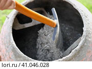 Construction site. Adding lime, sand and stones to rotating cement mixer. Builder working with shovel during concrete solution mortar preparation. Bricklayer job machine equipment. Cement slurry. Стоковое фото, фотограф Марина Демидюк / Фотобанк Лори