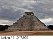 The famous pyramid of Kukulkan against the backdrop of a cloudy sky. A staircase leads to the top of the ancient stepped building, to the altar. Unesco heritage. Chichen Itza. Mexico (2018 год). Стоковое фото, фотограф Вера Ивановна Кубарева / Фотобанк Лори