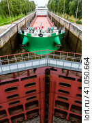 Vytegra, Russia - August 16, 2015: Cargo ship entered the White Sea-Baltic Canal Gateway. It connects the White Sea, in the Arctic Ocean, with Lake Onega, which is further connected to the Baltic Sea. Редакционное фото, фотограф VittoriaChe / Фотобанк Лори