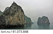 Islands with bizarre outlines and steep slopes are hidden in the fog. Reflection on the surface of the calm water of Halong Bay. Vietnam (2019 год). Стоковое фото, фотограф Вера Ивановна Кубарева / Фотобанк Лори