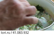Asian cuisine, cooking simple food (okroshka). The cook pours a milk drink into a pot of vegetables and stirs it with a spoon . Стоковое видео, видеограф Сергей Медведев / Фотобанк Лори