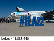 BERLIN, GERMANY - JUNE 23, 2022: ILA22 hashtag on the airfield. In the background is a wide-body jet airliner Airbus A350-900 XWB. Exhibition ILA Berlin Air Show 2022. Редакционное фото, фотограф Sergey Kohl / Фотобанк Лори