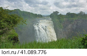River Zambezi flows from the plateau in the gorge. There is a fog on the abyss. In the foreground, a lush green grass. Victoria Falls. Zimbabwe. Стоковое фото, фотограф Вера Ивановна Кубарева / Фотобанк Лори