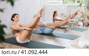 Three generation of women perform sitting boat pose Paripurna Navasana. Стоковое фото, фотограф Яков Филимонов / Фотобанк Лори