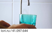 A jet of water flows into a glass. Drinking water from a tap. The man is fetching water. Стоковое видео, видеограф Алексей Круковский / Фотобанк Лори
