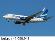 Самолет Boeing 737-700 (RA-73263) авиакомпании "Якутия" перед посадкой в голубом безоблачном небе (2023 год). Редакционное фото, фотограф Виктор Карасев / Фотобанк Лори