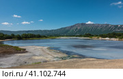 The caldera of an extinct volcano has a turquoise thermal lake with opaque water. Sulphurous deposits on the shores. A picturesque mountain range against a background of blue sky. Kamchatka. Uzon. Стоковое фото, фотограф Вера Ивановна Кубарева / Фотобанк Лори