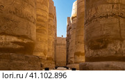 Colonnade in the hypostyle hall of the Karnak Temple. The columns stand in rows. Hieroglyphs and carvings are visible. Close-up. Blue sky. Egypt. Luxor (2021 год). Стоковое фото, фотограф Вера Ивановна Кубарева / Фотобанк Лори