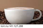 Drop of milk falling in a white cup with black coffee. Side View. Slow Motion. Coffee droplet. Roasted coffee beans background. Freshly brewed latte cappuccino. Close up. Coffee product advertising. Стоковое видео, видеограф Марина Демидюк / Фотобанк Лори