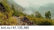 Panoramic view of a fertile Paul valley. Agriculture terraces in vertical valley sides, rugged peaks and motion clouds on horizon. Santo Antao, Cape Verde. Стоковое фото, фотограф Igor Tichonow / Фотобанк Лори