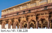 Ancient Indian architecture. The colonnade of the open hall is built of sandstone. Columns with carved capitals, arches, ornaments, patterns, lattices are visible. Blue sky. Amber Fort. Jaipur (2022 год). Стоковое фото, фотограф Вера Ивановна Кубарева / Фотобанк Лори