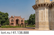 The complex of the tomb of Itmad-Ud-Daulah. A corner marble minaret with ornaments and inlays of precious stones is visible. In the distance is a red sandstone building with arches and domes. India. (2022 год). Стоковое фото, фотограф Вера Ивановна Кубарева / Фотобанк Лори