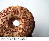 A doughnut or donut. A type of leavened fried dough. Sweet snack that can be homemade or purchased in bakeries, supermarkets, food stalls. Delicious pie with light icing on a white background. Стоковое фото, фотограф Юлия Петровская / Фотобанк Лори
