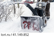 Snowblower removes snow, a man cleans the yard outside. Стоковое фото, фотограф Igor Skripachev / Фотобанк Лори