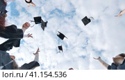 Joyful graduates stand in a circle and toss their caps up. Стоковое видео, видеограф Mikhail Davidovich / Фотобанк Лори