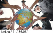 Graduating students twirl a geographic globe of the world in their hands. Стоковое видео, видеограф Mikhail Davidovich / Фотобанк Лори
